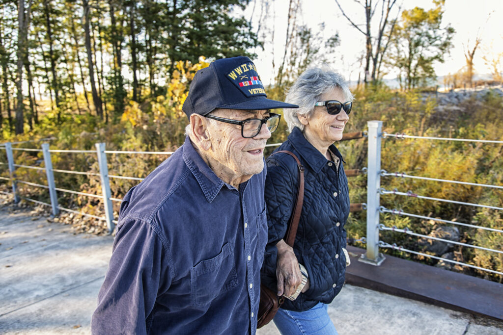 Announcing New Veteran's Benefits Program, Image is of a US Veteran and female family member walking.